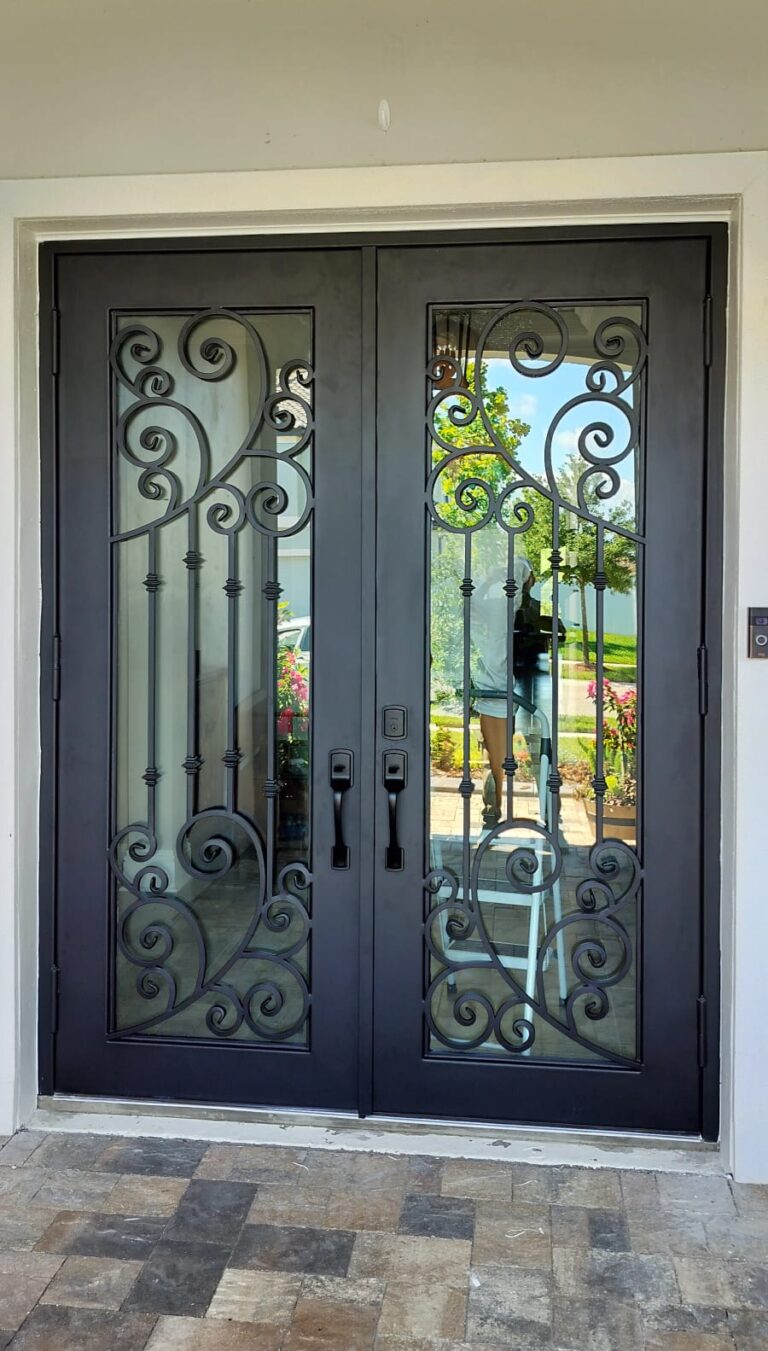 Custom ornamental double swing wrought iron door with impact glass